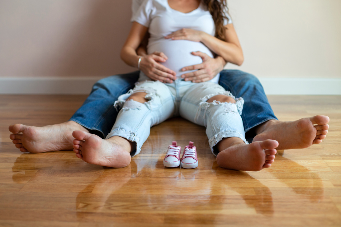 Future mom and dad feet with little baby shoes
